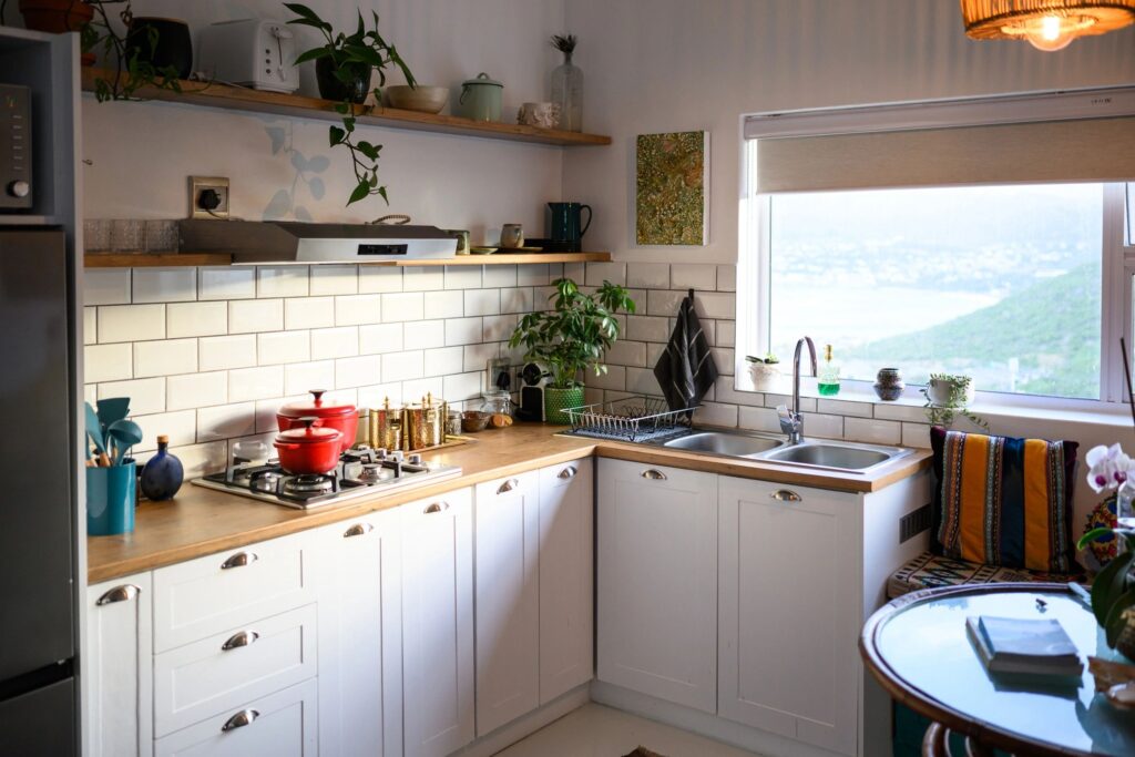 Shot of a bright, modern kitchen with white cabinets, wooden shelves, and tiles